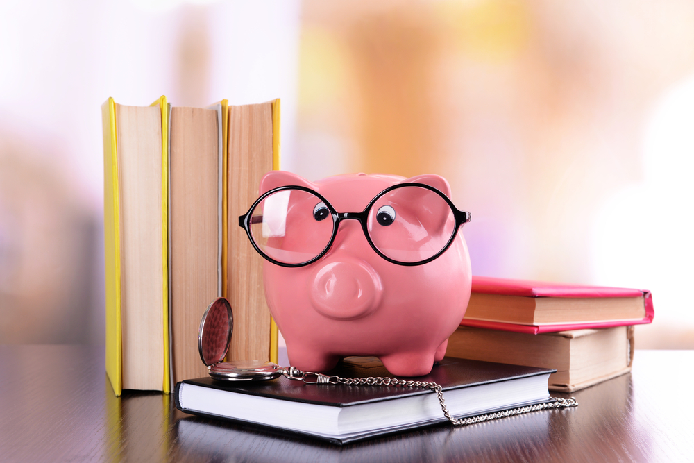 Piggy bank in glasses with books